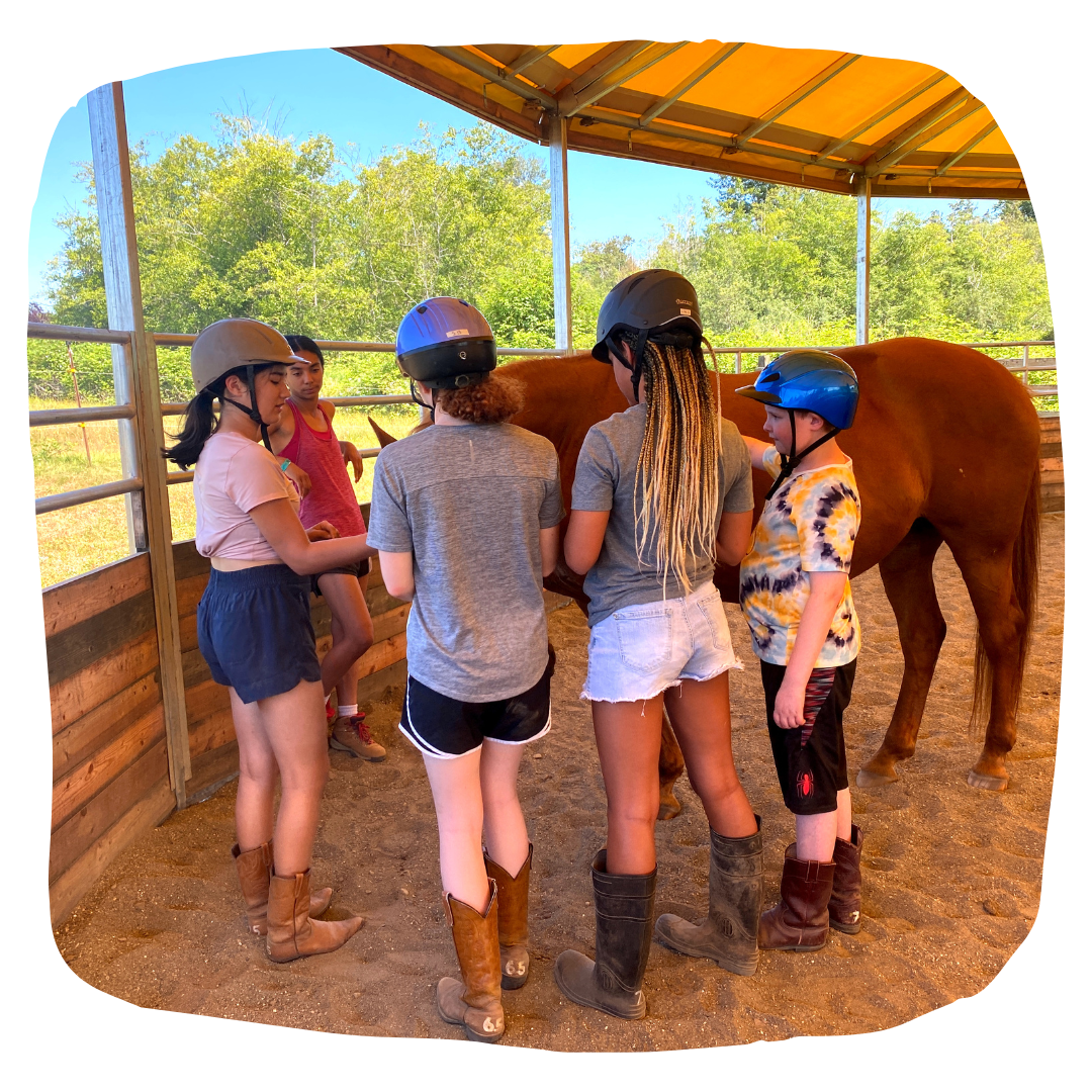 group of youth standing next to a horse