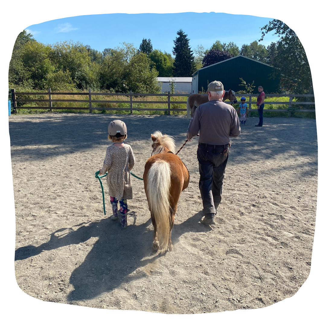 Miniature horse is led by young girl and older man