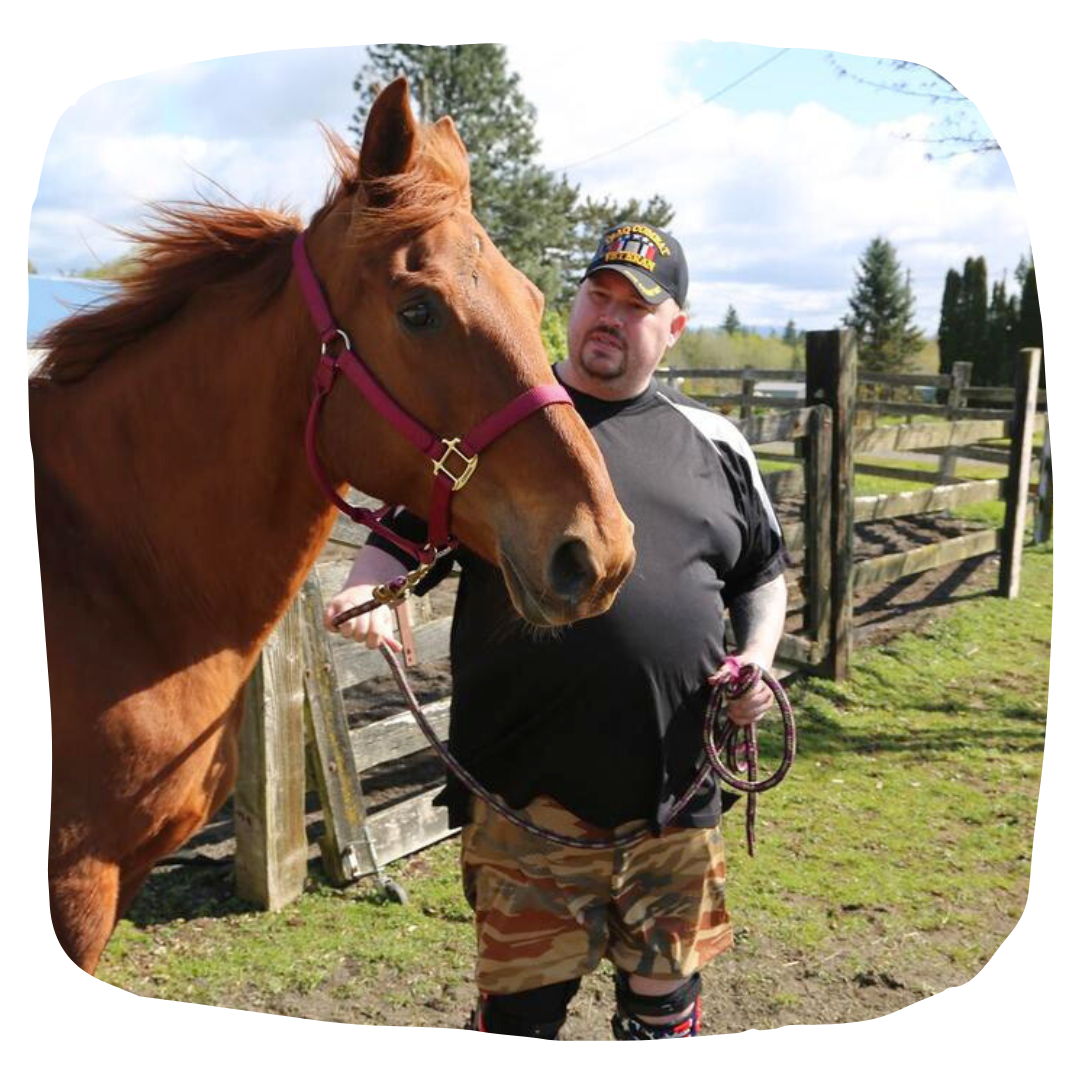 male veteran holds the halter of a horse