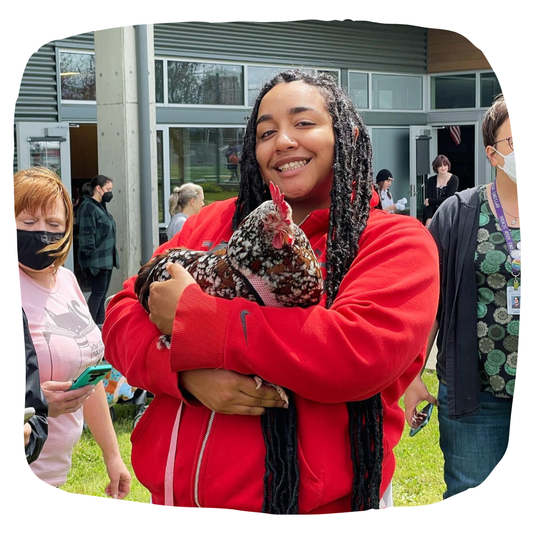 Black teenage holds speckled chicken